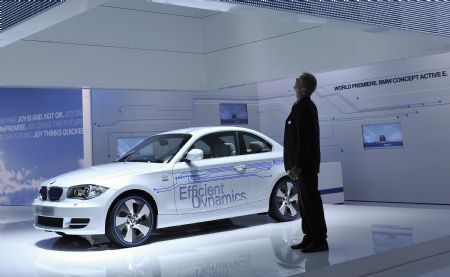 A man stands before the BMW Active E hybrid concept car during the second press preview day of the 2010 North American International Auto Show (NAIAS) at Cobo center in Detroit, Michigan, U.S.A., Jan. 12, 2010. [Xinhua]