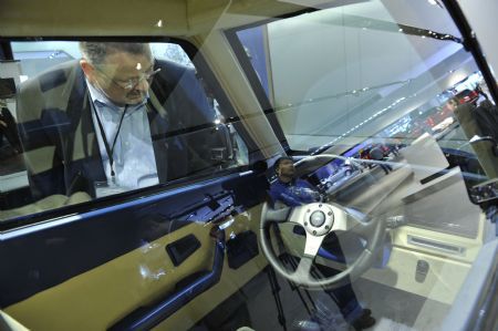 A man looks at a two-seat Commuter Cars Tango electric car at the Electric Avenue during the second press preview day of the 2010 North American International Auto Show (NAIAS) at Cobo center in Detroit, Michigan, U.S.A., Jan. 12, 2010. [Xinhua]