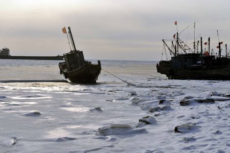 Fishing boats are seen trapped by sea ice in Laizhou Bay, east China's Shandong Province, Jan. 12, 2010. The most severe icing situation in the past 30 years in the coast off Shandong Province continued to worsen amid cold snaps. Sea ice appeared last week along the coastline of the Bohai Sea and northern Yellow Sea as cold fronts pushed the temperature down to minus 10 degrees Celsius.