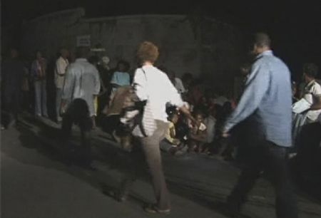Haitians are seen on the road outside the United Nations headquarters building after a major earthquake struck, in Port-au-Prince in this January 13, 2010 video grab. The headquarters of the U.N. mission in Haiti was seriously damaged by a powerful earthquake that shook the capital Port-au-Prince on Tuesday and many staff are missing, the United Nations said. [Xinhua/Reuters]