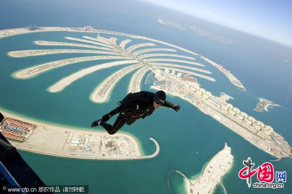 A female skydiver thumbs up as she jumps over the Palm island during the International Parachuting World Championship in Dubai, January 13, 2010. [CFP]