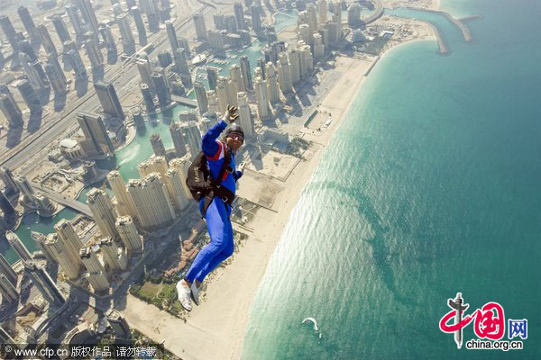 A skydiver exits an aircraft over Dubai Marina as he competes in the International Parachuting World Championship in Dubai, January 13, 2010. [CFP]