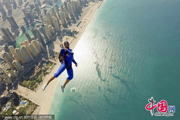 A skydiver exits an aircraft over Dubai Marina as he competes in the International Parachuting World Championship in Dubai, January 13, 2010. [CFP]