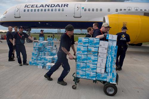 An Icelandic rescue worker unloads cases of water as they arrive at Port-au-Prince&apos;s airport on January 13, 2009, one day after an eartquake measuring 7.0 hit the Haitian capital. More than 100,000 people were feared dead Wednesday after a cataclysmic earthquake struck Haiti, filling the streets with corpses and burying thousands under razed schools, hotels and hospitals. [Xinhua/AFP]
