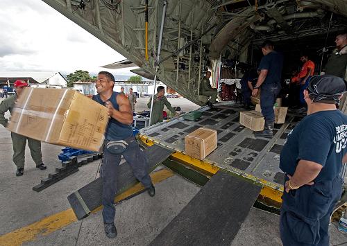 Rescue workers unload medical and other relief supplies flown-in on a Venezuelan military cargo plane January 13, 2010 in Port-Au-Prince, one day after a cataclysmic earthquake struck Haiti. More than 100,000 people are feared dead. [Xinhua/AFP]