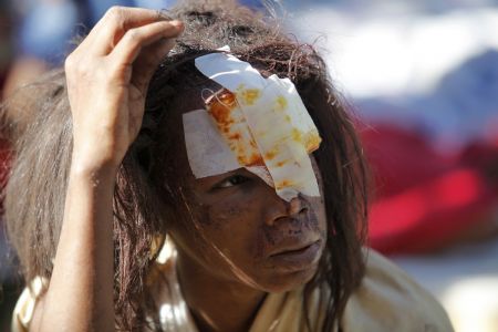 An injured resident waits for medical attention after an earthquake in Port-au-Prince January 13, 2010.(Xinhua/Reuters Photo)