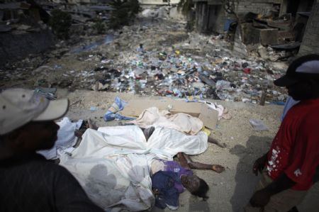 Resident walk next to dead bodies after an earthquake in Port-au-Prince January 13, 2010.(Xinhua/Reuters Photo)