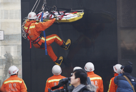 Chinese firefighters take part in an exercise in case of emergencies during the Shanghai World Expo 2010 in Shanghai, Jan. 14, 2010. [Xinhua]