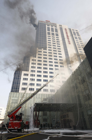 Chinese firefighters take part in an exercise in case of emergencies during the Shanghai World Expo 2010 in Shanghai, Jan. 14, 2010. [Xinhua]