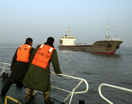 A police boat approaches the vessel 'junrong 9' in the East China Sea off the coast of Wenling City, east China's Zhejiang Province, Jan. 14, 2010. One died and another four people were missing Wednesday after a fishing boat 'Zhelingyu 4238' collided with the cargo vessel 'Junrong 9' at about 7:45 p.m. in the East China Sea. (Xinhua/Zhou Junjun)