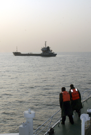 A police boat approaches the vessel 'junrong 9' in the East China Sea off the coast of Wenling City, east China's Zhejiang Province, Jan. 14, 2010.(Xinhua/Zhou Junjun) 