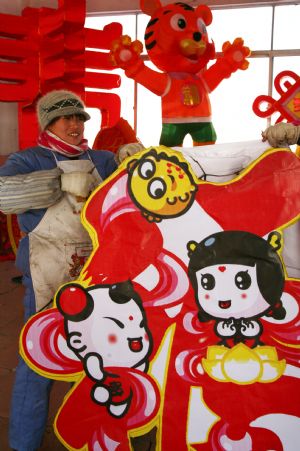 A folk craftswoman decorates a large lantern at a handicraft factory in Rushan, east China's Shandong Province, Jan. 14, 2010.