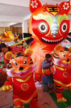 Folk craftswomen decorate a large lantern at a handicraft factory in Rushan, east China's Shandong Province, Jan. 14, 2010. 