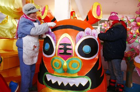 Folk craftswomen decorate a large lantern at a handicraft factory in Rushan, east China's Shandong Province, Jan. 14, 2010. 