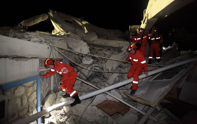 Members of a Chinese emergency rescue team inspect the collapsed building of the headquarters of the UN Stabilization Mission in Port-au-Prince, Haiti, Jan. 14, 2010. The Chinese emergency rescue team arrived in Haiti's capital Port-au-Prince early Thursday local time, to help the rescue operation after an earthquake in which up to 100,000 people are feared dead and eight Chinese are still missing. [Xinhua] 