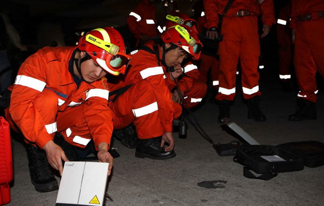 Chinese emergency rescue team members set up maritime satellite after arriving at the airport in Haitian capital Port-au-Prince on Jan. 14, 2010. The rescue team arrived here early Thursday local time, to help the rescue operation after an earthquake in which up to 100,000 people are feared dead and eight Chinese are still missing. [Xinhua]