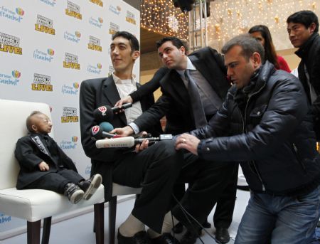 He Pingping (L) of China and Sultan Kosen of Turkey talk with members of the media during a promotional event in Istanbul January 14, 2010. He, with a height of 73 cm (2 feet 5 inch), and Kosen, with a height of 246.5 cm (8 feet 1 inch), are listed in the Guinness World Records as the world&apos;s shortest man and tallest man respectively..[Xinhua/Reuters]