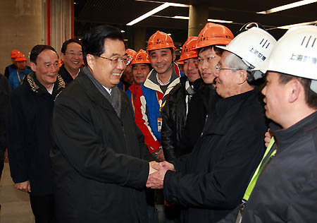 Hu Jintao (L front), general secretary of the Central Committee of the Communist Party of China, Chinese president and chairman of the Central Military Commission, shakes hands with workers and personnel who work for the construction of the Shanghai World Expo park in Shanghai, east China, Jan. 15, 2010. Hu Jintao paid a visit here to inspect the preparation of Shanghai World Expo on Jan. 15. [Xinhua]