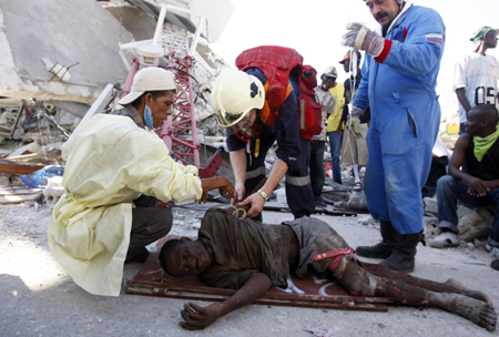 Rescuers provide medical aid to an earthquake victim named Perst, 35, in the capital Port-au-Prince January 15, 2010. [Xinhua]