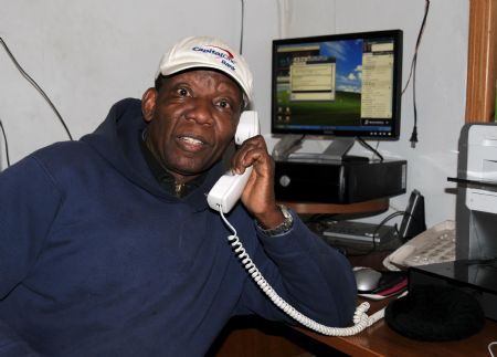 A staff member of a Haitian Radio station answers the phone from a listener in the studio in New York, the United States, Jan. 15, 2010. The radio station helps Haitian in New York to find their relatives and friends by linking with radio station in Haiti. 