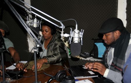 Staff members of a Haitian Radio station work in the studio in New York, the United States, Jan. 15, 2010. The radio station helps Haitian in New York to find their relatives and friends by linking with radio station in Haiti. 