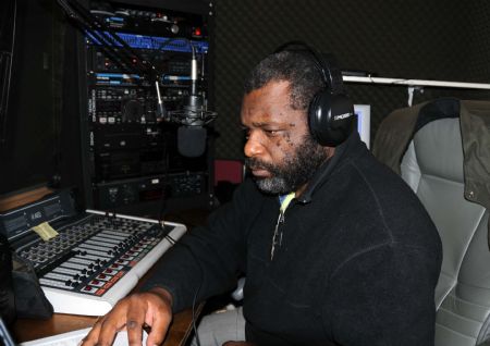 A staff member of a Haitian Radio station listens to an audience in the studio in New York, the United States, Jan. 15, 2010. The radio station helps Haitian in New York to find their relatives and friends by linking with radio station in Haiti. 