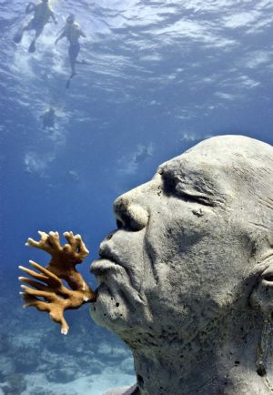 Divers swim near British artist Jason de Caires Taylor's sculpture 'The Man on Fire' in this undated handout in the Mexican resort of Cancun. At the bottom of its turquoise waters and playing with the reflections of the sun at sea, a series of sculptures were immersed in the Mexican resort of Cancun in what aspires to be a huge underwater museum that harmonizes with the beauty of its coral reefs. 