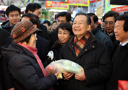 Chinese Premier Wen Jiabao, who is also a member of the Standing Committee of the Political Bureau of the Communist Party of China Central Committee, talks with local residents at a supermarket during his inspection in Beijing, Jan. 16, 2010. [Photo: Xinhua] 