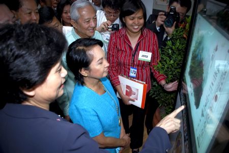 Philippine President Gloria Macapagal-Arroyo (2nd L, front) watches the electronic library of the newly inaugurated Confucius Institute at Angeles University Foundation in Angeles, northern Philippines' Pampanga Province, on January 15, 2010. [Xinhua photo]