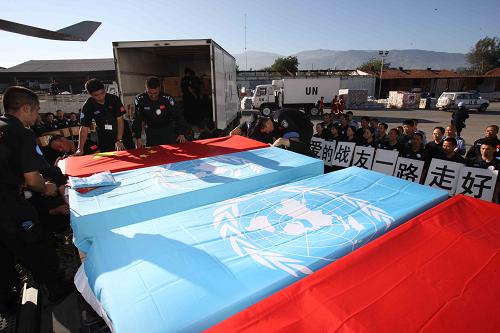 Flag-draped coffins of eight Chinese police officers who died in the Haiti quake are being unloaded from a UN truck for a trip back to China in Port-au-Prince, capital of Haiti, January 17, 2010. [Xinhua] 