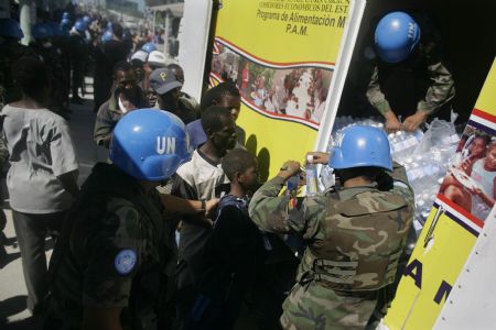 United Nations peacekeepers distribute bottles of water to locals in Haitian capital Port-au-Prince on Jan. 16, 2010. International rescuers are rushing to Haiti following a devastating earthquake on Jan. 12. (Xinhua)