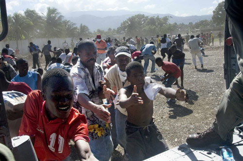 Haitian citizens receive water from United States air crewmen from Helicopter Sea Combat Squadron (HSC) 9 assigned to the aircraft carrier USS Carl Vinson (CVN 70) in Port-au-Prince, January 16, 2009. 