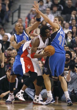 Toronto Raptors forward Chris Bosh (C) drives to the basket against Dallas Mavericks defenders Shawn Marion (L) and Dirk Nowitzki (R) during the second half of their NBA basketball game in Toronto January 17, 2010. 