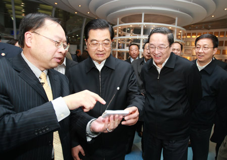 Hu Jintao (2nd L, front), general secretary of the Central Committee of the Communist Party of China, Chinese president and chairman of the Central Military Commission, tries the TV and video communication functions of a mobile phone as he inspects Spreadtrum Communications, Inc., in Shanghai, east China, on Jan. 16, 2010. Hu Jintao made an inspection tour in Shanghai on Jan. 14-17. [Xinhua]