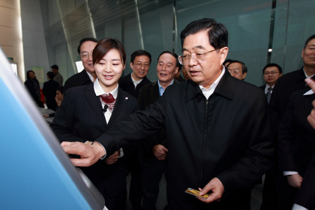 Hu Jintao (front), general secretary of the Central Committee of the Communist Party of China, Chinese president and chairman of the Central Military Commission, tries the bankcard service of China Unionpay (CUP) as he inspects CUP in Shanghai, east China, on Jan. 16, 2010. Hu Jintao made an inspection tour in Shanghai on Jan. 14-17. [Xinhua]