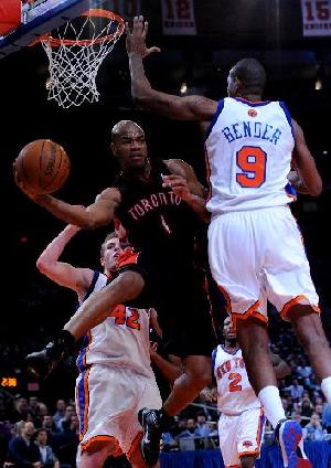 Jarrett Jack(C) of Toronto Raptors jumps to pass the ball during their NBA basketball game against New York Knicks in New York, the United States, Jan. 15, 2010. (Xinhua/Reuters Photo)  