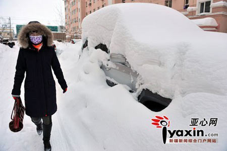 A local resident walks past a snow-covered car in Altay, Xinjiang Uygur Autonomous Region in this undated photo. [iyaxin.com]