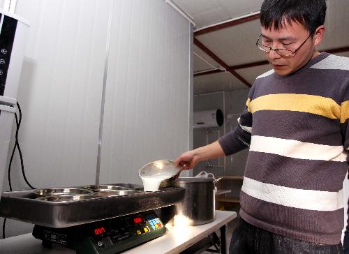Feeder Li Guo prepares supper for giant pandas at Shanghai Zoo in Shanghai, the host city of the 2010 World Expo, in east China, Jan. 15, 2010. [Xinhua]