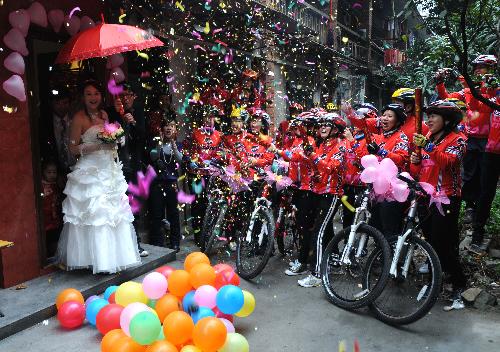 Cyclists wait for the bride at her door in Liuzhou, southwest China&apos;s Guangxi Zhuang Autonomous Region, Jan. 20, 2010. A newly-married couple held a bicycle wedding accompanied by more than 30 cyclist friends of the bridegroom in Liuzhou on Wednesday. [Xinhua]
