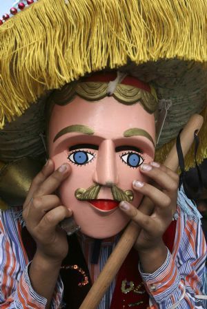 A parishioner wearing a Saint Sebastian mask, rests after dancing in the streets of Diriamba to mark the Feast of Saint Sebastian January 20, 2010. [Xinhua/Reuters]