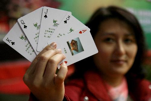 An employee demonstrates some playing cards with promotion words and images for the 2010 Shanghai World Expo at the Jinshan District in Shanghai, China, Jan. 20. [Xinhua]