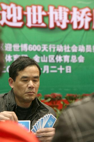 Photo taken on Jan. 20, 2010, shows a man attending a bridge competition at the Jinshan District in Shanghai, China. Cards with signifiers of the 2010 Shanghai World Expo were used in the competition. [Xinhua]