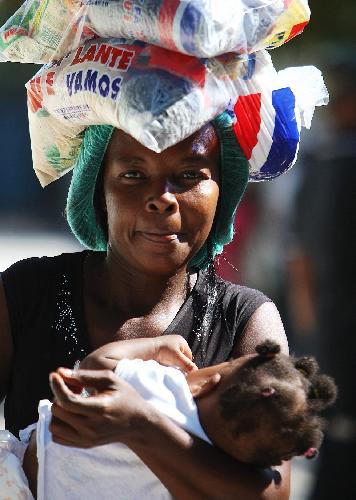 A Haitian woman queues to receive aid supplies in Port-au-Prince, Haiti, Jan. 20, 2010. (Xinhua/Xing Guangli)