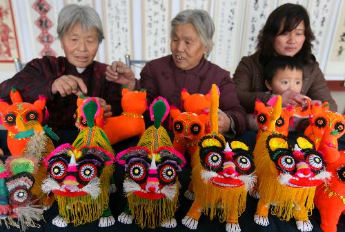 Several farmers are engrossed in elaborating tiger dolls at Guanzhuang Village, Wenxi County, north China's Shanxi Province, Jan. 19, 2010. With the approaching of the Year of Tiger according to traditional Chinese lunar calendar, local villagers start making varieties of delicate ornamental articles for the Spring Festival. [Xinhua photo]