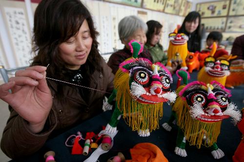 A young woman is engrossed in elaborating tiger dolls at Guanzhuang Village, Wenxi County, north China's Shanxi Province, Jan. 19, 2010. With the approaching of the Year of Tiger according to traditional Chinese lunar calendar, local villagers start making varieties of delicate ornamental articles for the Spring Festival. [Xinhua photo]