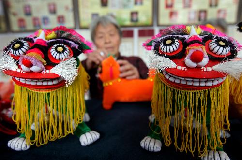 An old granny is engrossed in elaborating tiger dolls at Guanzhuang Village, Wenxi County, north China's Shanxi Province, Jan. 19, 2010. With the approaching of the Year of Tiger according to traditional Chinese lunar calendar, local villagers start making varieties of delicate ornamental articles for the Spring Festival. [Xinhua photo]