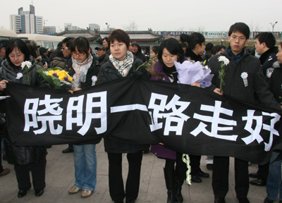 Mourners hold a banner: 'Xiaoming, take care.' [China.org.cn]