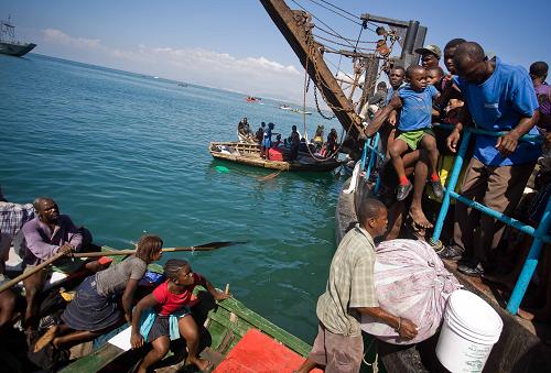 Local citizens try to flee this destroyed city by boat in Port-au-Prince, Haiti, Jan. 20, 2010. [David de la Pas/Xinhua]