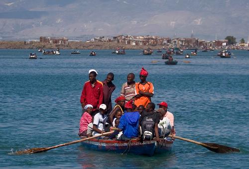 Local citizens try to flee this destroyed city by boat in Port-au-Prince, Haiti, Jan. 20, 2010. [David de la Pas/Xinhua]