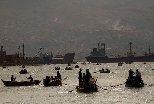 Local citizens try to flee this destroyed city by boat in Port-au-Prince, Haiti, Jan. 20, 2010. [David de la Pas/Xinhua]